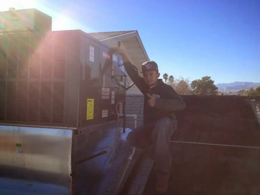 HVAC technician performing AC Tune-Up on a rooftop unit in Pearl